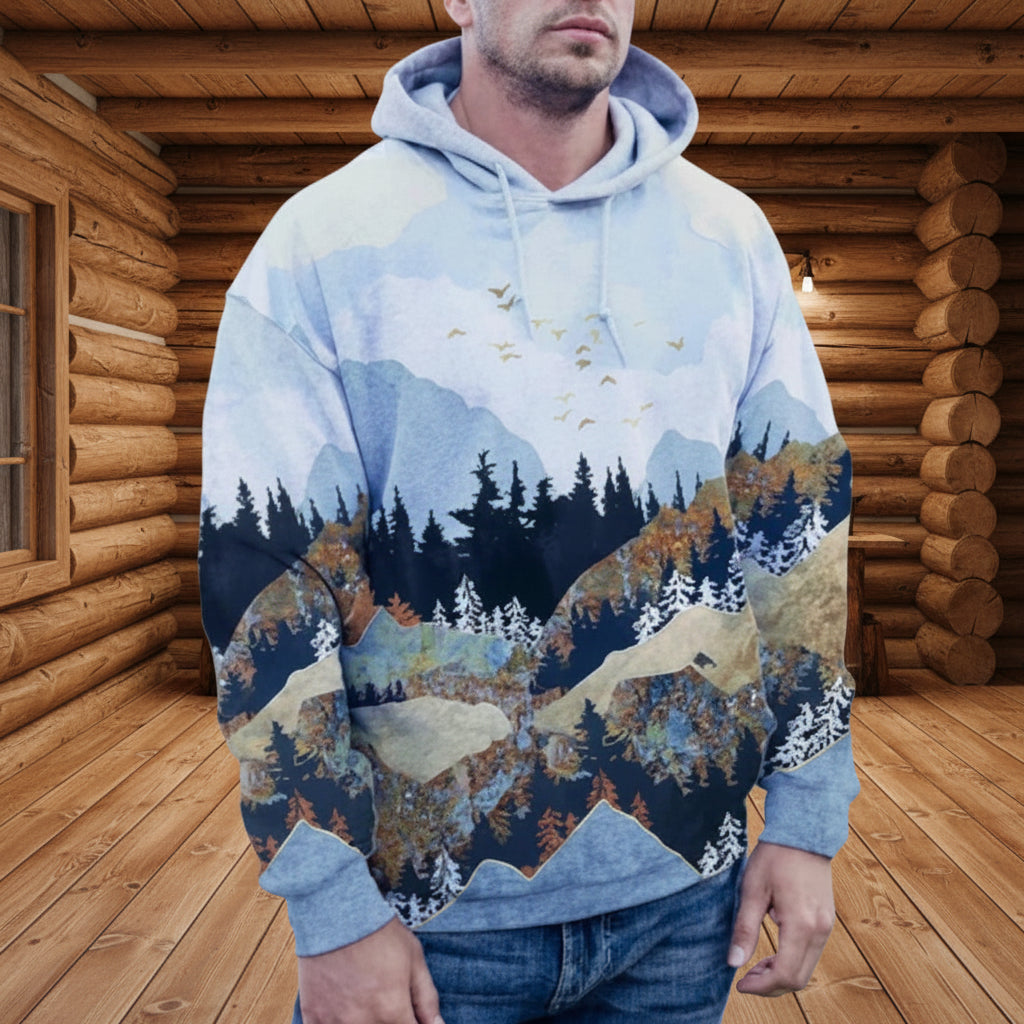 Person wearing a hoodie with a nature-themed design in a mountainous landscape