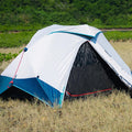 Camping tent with blue and white design in a natural setting