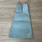 Blue open top leather bag on a wood surface.