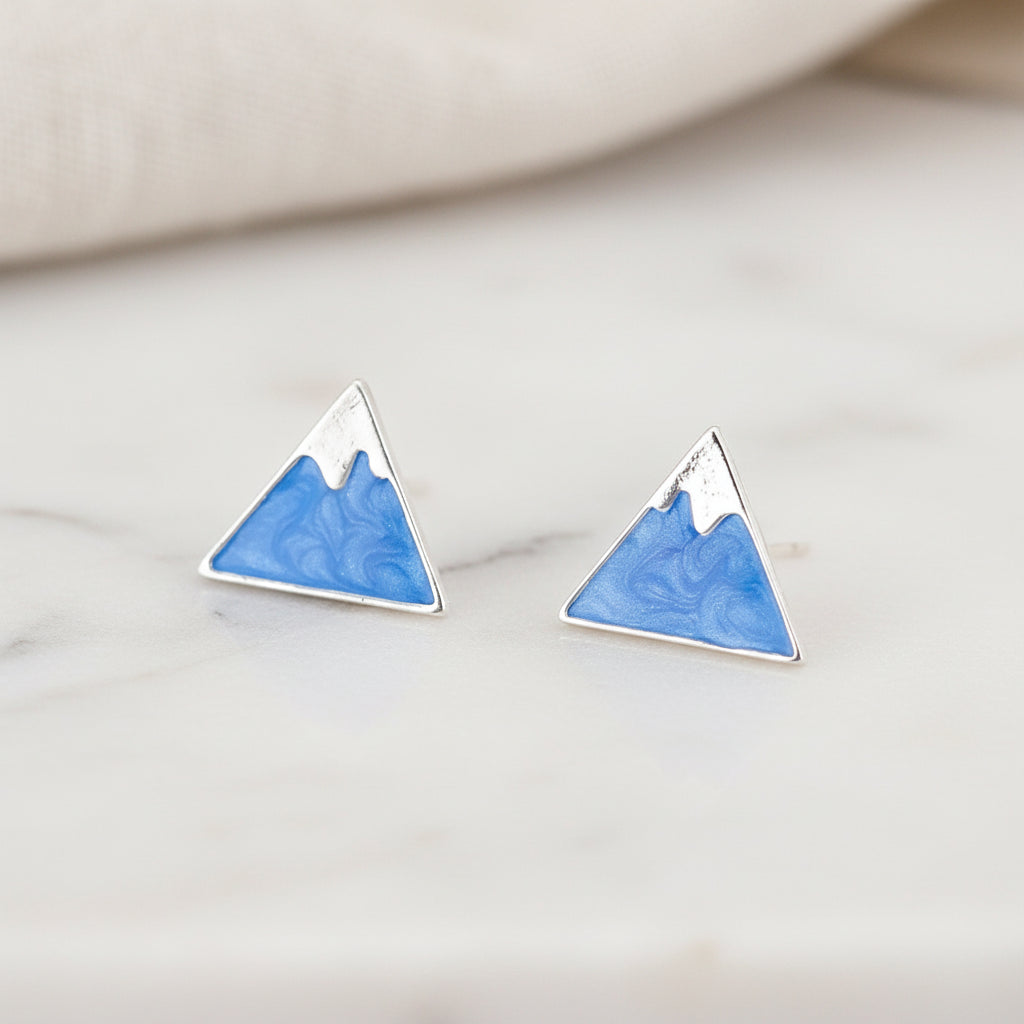 Mountain Peak Stud Earrings on marble.