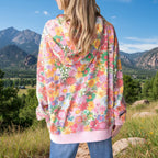 Person wearing a colorful floral hoodie with a Colorado Mountain background.