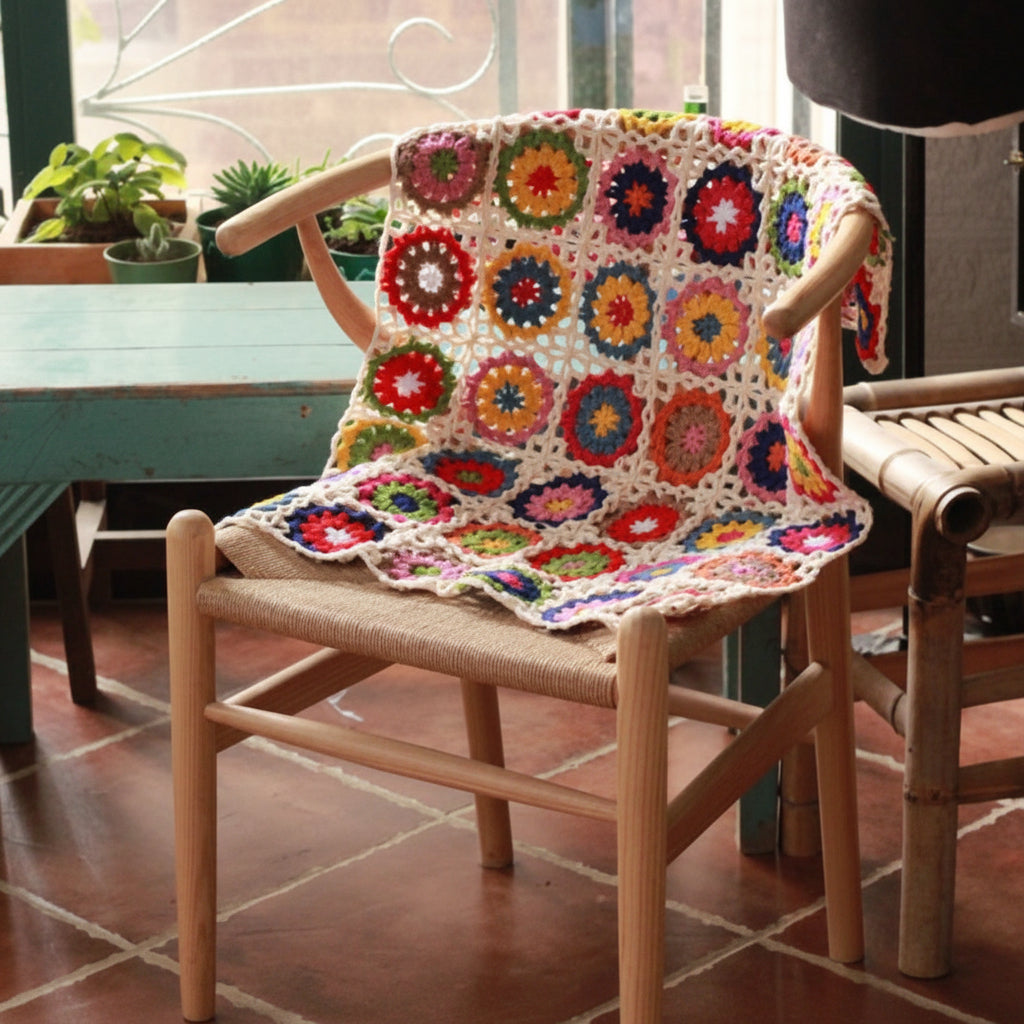 Chair with a colorful crochet blanket on a tiled floor