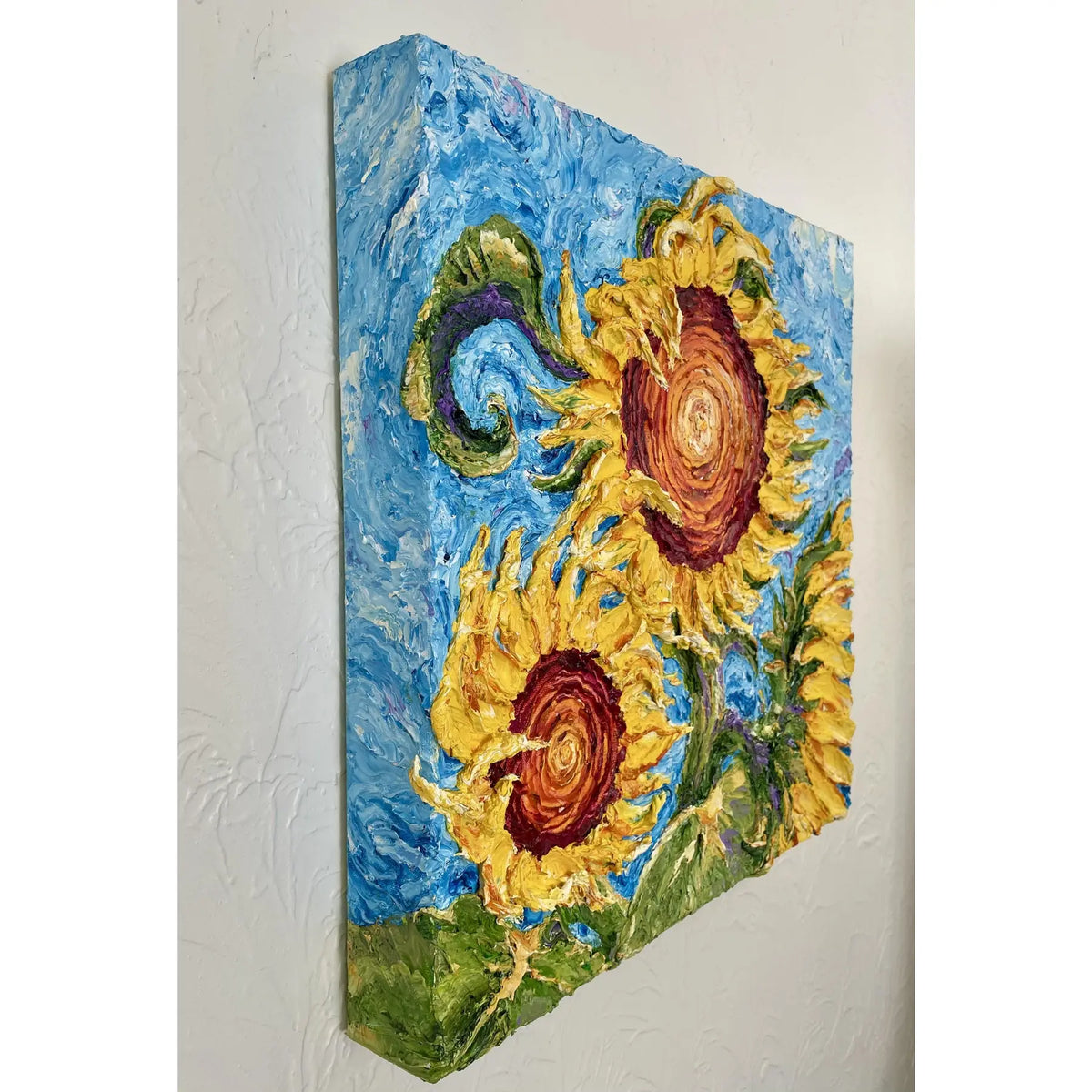 Angled detail of golden sunflowers and swirling blue oil paint