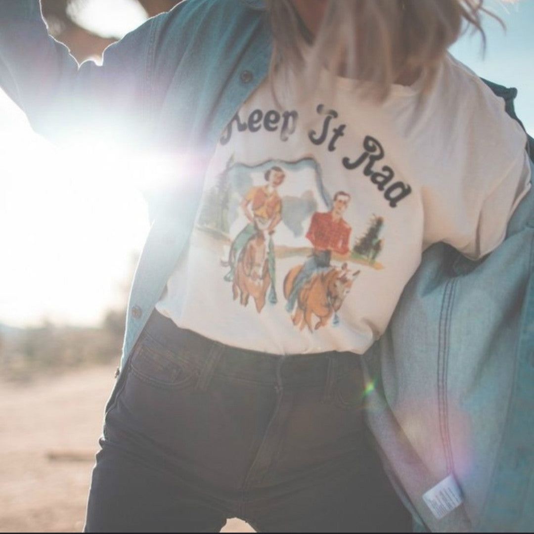 Person wearing a graphic t-shirt with text and images outdoors